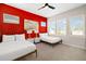 Bright bedroom featuring two beds, bold accent wall, and ample natural light at 1514 Corolla Ct, Reunion, FL 34747