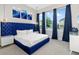 Comfortable bedroom with a plush blue headboard, bright windows, and contemporary artwork at 1514 Corolla Ct, Reunion, FL 34747