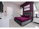 Chic bedroom with a velvet-tufted headboard, purple accent wall, and modern white nightstands, creating a luxurious space at 1514 Corolla Ct, Reunion, FL 34747