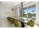 Elegant dining area features a large table, modern lighting, and a view of the outdoor patio at 1514 Corolla Ct, Reunion, FL 34747