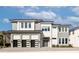 Contemporary two-story home showcasing a three-car garage, light-colored stone facade, and inviting front entrance at 1514 Corolla Ct, Reunion, FL 34747