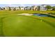 Scenic view of the golf course in front of a row of houses under a clear blue sky at 1514 Corolla Ct, Reunion, FL 34747