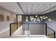 Bright hallway featuring modern railing and unique gold sphere light fixture adding elegance to the home at 1514 Corolla Ct, Reunion, FL 34747