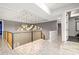 Elegant hallway featuring a modern chandelier, stylish railing, and marble-look floors at 1514 Corolla Ct, Reunion, FL 34747