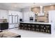 Bright kitchen features a large island with seating, sleek cabinetry, and modern lighting fixtures at 1514 Corolla Ct, Reunion, FL 34747