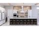 Modern kitchen boasts an expansive island with seating, brick accent wall, and stainless steel appliances at 1514 Corolla Ct, Reunion, FL 34747