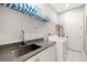 Functional laundry room with a sink, countertop, ample storage, and modern appliances at 1514 Corolla Ct, Reunion, FL 34747
