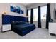 Elegant main bedroom with a plush blue headboard, stylish lighting, and large windows offering ample natural light at 1514 Corolla Ct, Reunion, FL 34747