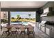Relaxing patio with an outdoor kitchen, dining area, and views of the pool and golf course at 1514 Corolla Ct, Reunion, FL 34747