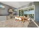 Modern outdoor kitchen with stainless steel appliances, dining area, and sliding glass doors to the interior at 1514 Corolla Ct, Reunion, FL 34747