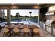 Outdoor kitchen with a grill and a dining area overlooking the pool and golf course views at 1514 Corolla Ct, Reunion, FL 34747
