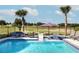 Inviting pool area features relaxing lounge seating, an umbrella and a serene golf course view at 1514 Corolla Ct, Reunion, FL 34747
