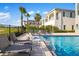 Luxury pool area with sleek lounge chairs, palm trees, and lush landscaping for ultimate relaxation at 1514 Corolla Ct, Reunion, FL 34747