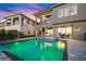 Backyard pool area features modern lounge chairs and lights to create a relaxing evening atmosphere at 1514 Corolla Ct, Reunion, FL 34747