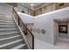 Bright open staircase features sleek black and gold railings and stylish wall decor creating an elegant focal point at 1514 Corolla Ct, Reunion, FL 34747
