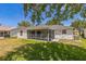 Spacious backyard featuring a screened-in lanai, lush green grass, and a private outdoor space for relaxation and entertainment at 2382 Due West Dr, The Villages, FL 32162