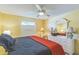 Bright bedroom with neutral walls, featuring a ceiling fan, a bed, and a mirrored dresser at 2382 Due West Dr, The Villages, FL 32162
