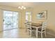 Cozy dining area featuring a wood table, a white chair set, and sliding glass doors to a screened in lanai at 2382 Due West Dr, The Villages, FL 32162