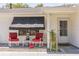 Inviting front porch with comfortable rocking chairs, a small table, and decorative plants enhancing the home's curb appeal at 2382 Due West Dr, The Villages, FL 32162