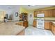 Well-equipped kitchen with wood cabinets, white appliances, and a breakfast bar, ideal for everyday meals and gatherings at 2382 Due West Dr, The Villages, FL 32162