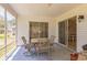 Enclosed patio with seating area, offering a relaxed outdoor space, with a view of the lush landscaping at 2382 Due West Dr, The Villages, FL 32162