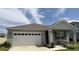 Charming single-story home with a two-car garage, covered porch, and well-maintained landscaping at 5216 Greenheart Ave, Mount Dora, FL 32757
