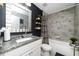 Stylish bathroom featuring granite countertops, decorative mirror, modern fixtures, and tiled shower-tub combination at 13257 Sw 29Th Cir, Ocala, FL 34473