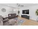 Comfortable living room features a modern ceiling fan, television, wood floors, and a stylish area rug at 3153 Legends Preserve Dr, Daytona Beach, FL 32124
