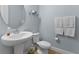 Modern powder room with a pedestal sink, toilet, and stylish silver-gray walls and accessories at 3153 Legends Preserve Dr, Daytona Beach, FL 32124