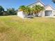 Home exterior featuring a lawn, attached garage, and palm trees at 323 Miami Ln, Kissimmee, FL 34759