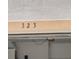 Close-up of the house numbers '323' above the garage entrance, painted dark against a light tan background at 323 Miami Ln, Kissimmee, FL 34759