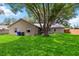 Spacious backyard showcasing lush green grass, mature trees and the home's exterior at 5003 Timber Ridge Trl, Ocoee, FL 34761