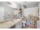 Well-lit bathroom features a decorative shower curtain, a sleek vanity, and tiled flooring at 5003 Timber Ridge Trl, Ocoee, FL 34761