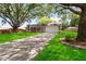 A well maintained front yard features lush landscaping and mature tree shading the house at 5003 Timber Ridge Trl, Ocoee, FL 34761
