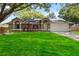 Charming single-story home with a lush green lawn and vibrant red landscaping creating curb appeal at 5003 Timber Ridge Trl, Ocoee, FL 34761