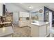 Bright kitchen with white cabinets, tile floors, and a view of the backyard through a large window at 5003 Timber Ridge Trl, Ocoee, FL 34761