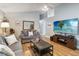 Bright living room with wood floors, comfortable seating, vaulted ceiling, and large television screen at 5003 Timber Ridge Trl, Ocoee, FL 34761