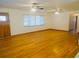 Bright living room features hardwood floors, window with blinds, and ceiling fans at 902 S Scenic Hwy, Lake Wales, FL 33853