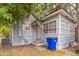 Back of the house with weathered siding, small porch with white door, and blue recycling bin at 515 New York Ave, St Cloud, FL 34769