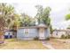 Exterior of home with light blue siding, white trim, small front porch and overgrown yard at 515 New York Ave, St Cloud, FL 34769