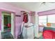 View of the laundry room with washer and dryer, pink walls and small window at 515 New York Ave, St Cloud, FL 34769