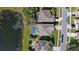 Aerial view of neighboring homes with screened pools, lush lawns, and a serene pond at 13532 Meadow Bay Loop, Orlando, FL 32824