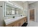 Sleek bathroom featuring a double vanity with modern fixtures, an illuminated mirror, and neutral decor at 13532 Meadow Bay Loop, Orlando, FL 32824