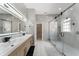 Modern bathroom design featuring double sinks, a large mirror with lighting, and a glass-enclosed shower at 13532 Meadow Bay Loop, Orlando, FL 32824