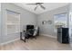 Bedroom with neutral colors, a ceiling fan, a desk with computer, and a mini fridge at 13532 Meadow Bay Loop, Orlando, FL 32824