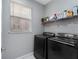 Laundry room with modern appliances, neutral walls, and shelving for ample storage at 13532 Meadow Bay Loop, Orlando, FL 32824