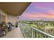 Relaxing balcony featuring comfortable seating and stunning views of the colorful evening sky and lush golf course at 4 Oceans West Blvd # 502B, Daytona Beach, FL 32118