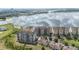 Aerial view of residential apartment buildings, meticulously landscaped grounds, and a scenic lake at 8749 The Esplanade # 6, Orlando, FL 32836