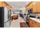 Open kitchen with stainless appliances, wood cabinets, and a view into the expansive living area at 8749 The Esplanade # 6, Orlando, FL 32836