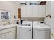 Functional laundry room with a washer, dryer, sink, and overhead storage cabinets at 8749 The Esplanade # 6, Orlando, FL 32836